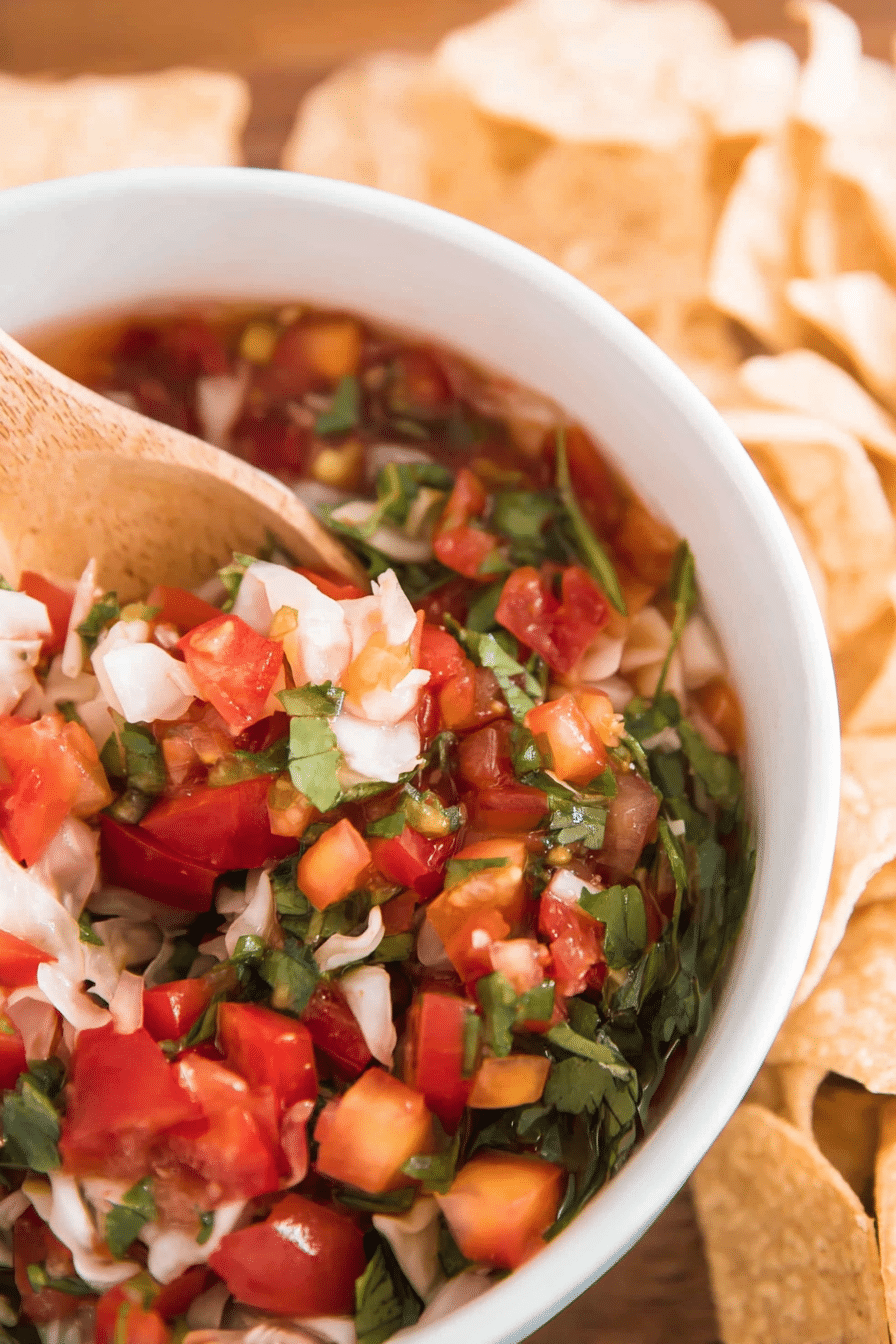Bowl of vibrant lacto fermented salsa with colorful diced vegetables and fresh cilantro.