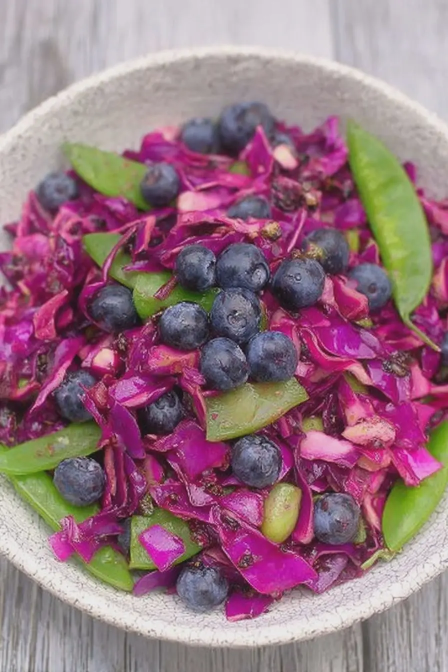 Red cabbage blueberry salad with snap peas and mint in a white bowl