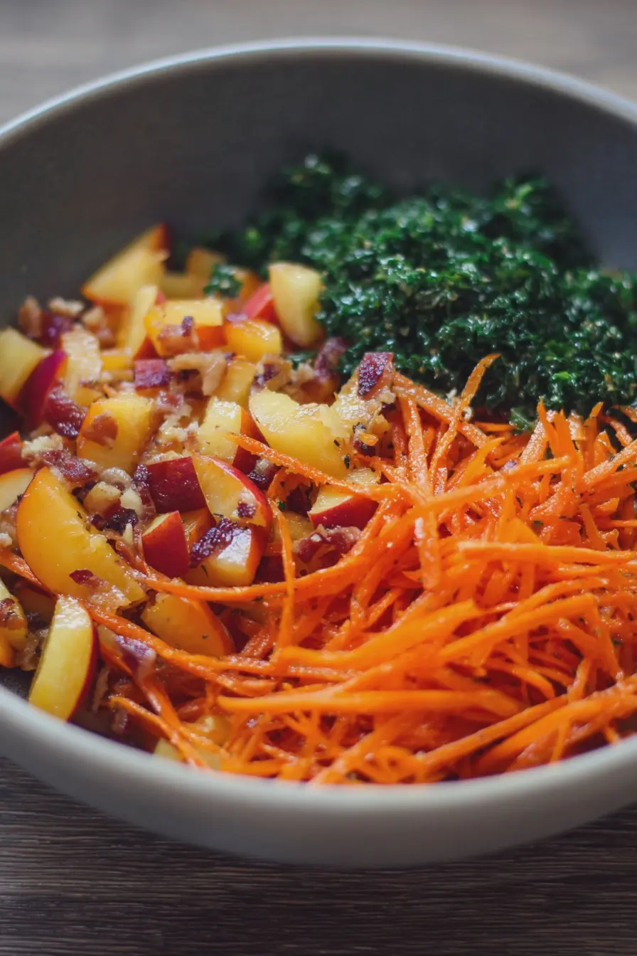 A colorful Carrot Nectarine Salad featuring shredded carrots, diced nectarines, and chopped cilantro, topped with toasted cashews.