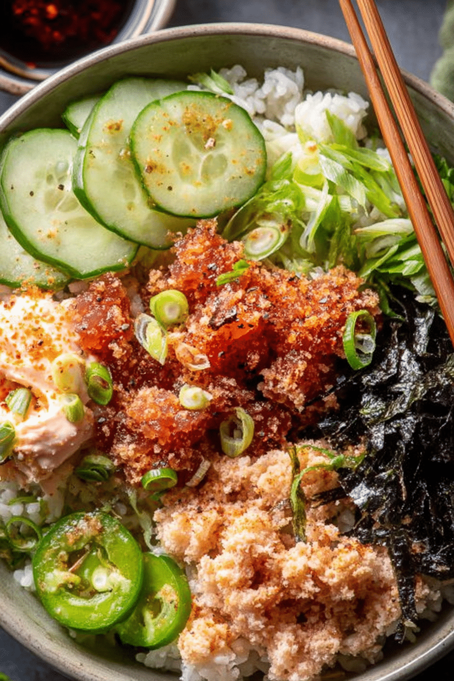 Spicy Tuna Sushi Bowl with crispy rice, cucumbers, and scallions on a wooden table