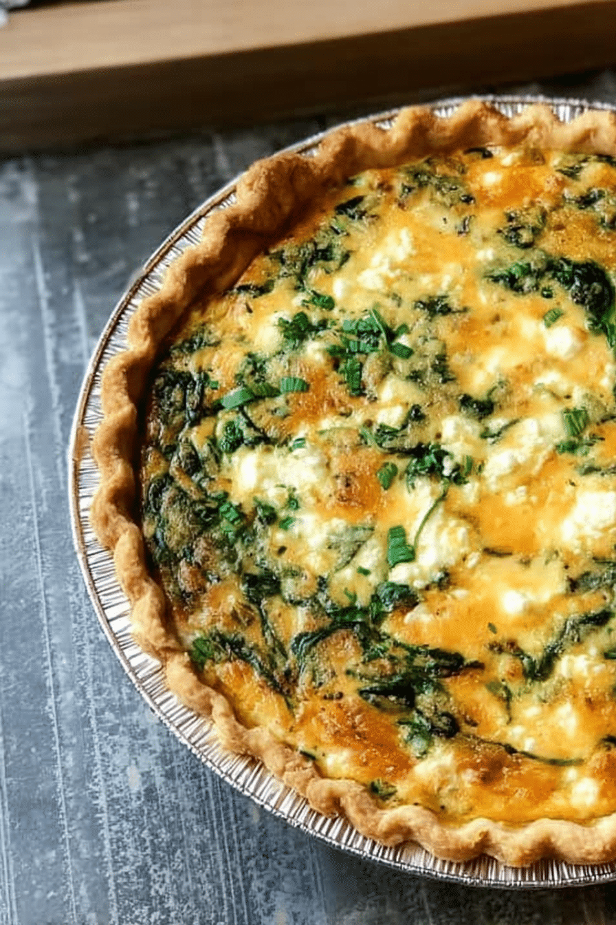 Slice of spinach feta quiche on a wooden table, garnished with herbs, showcasing the creamy texture and color.