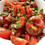 Fresh Lebanese tomato salad with cucumbers, parsley, and mint, showcasing Mediterranean flavors.