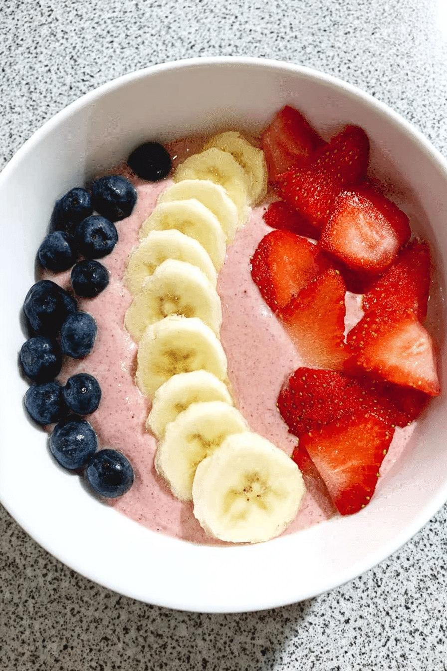 5-minute fruit smoothie bowl topped with sliced fruits, granola, and seeds, perfect for a refreshing breakfast.