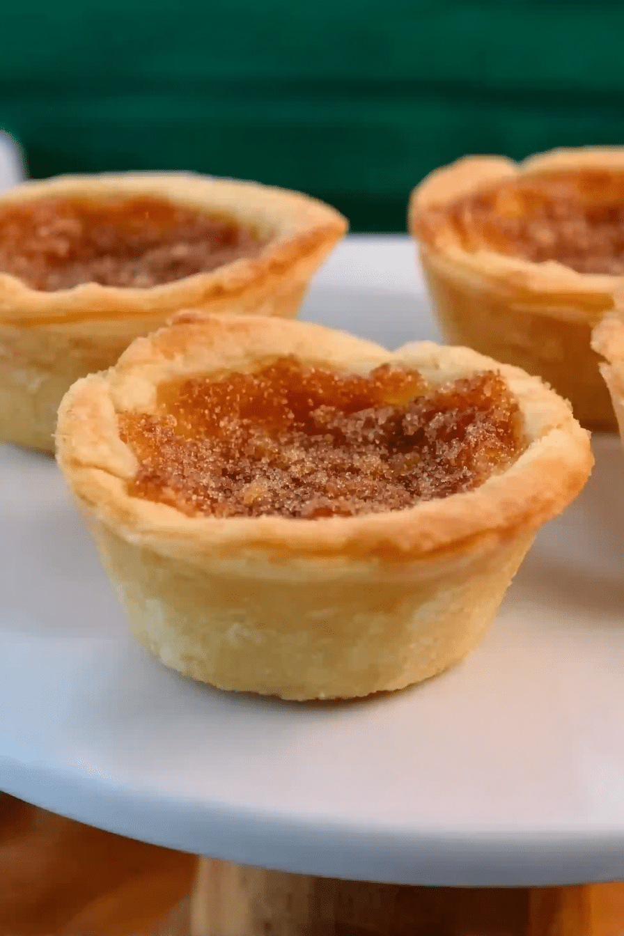 Delicious homemade Mom's Old Fashioned Butter Tarts with ingredients on a rustic wooden table