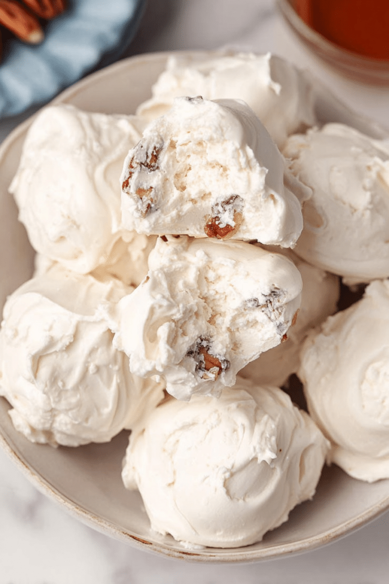 Close-up of old-fashioned divinity candy pieces on a vintage plate, highlighting their airy texture and pecan topping.