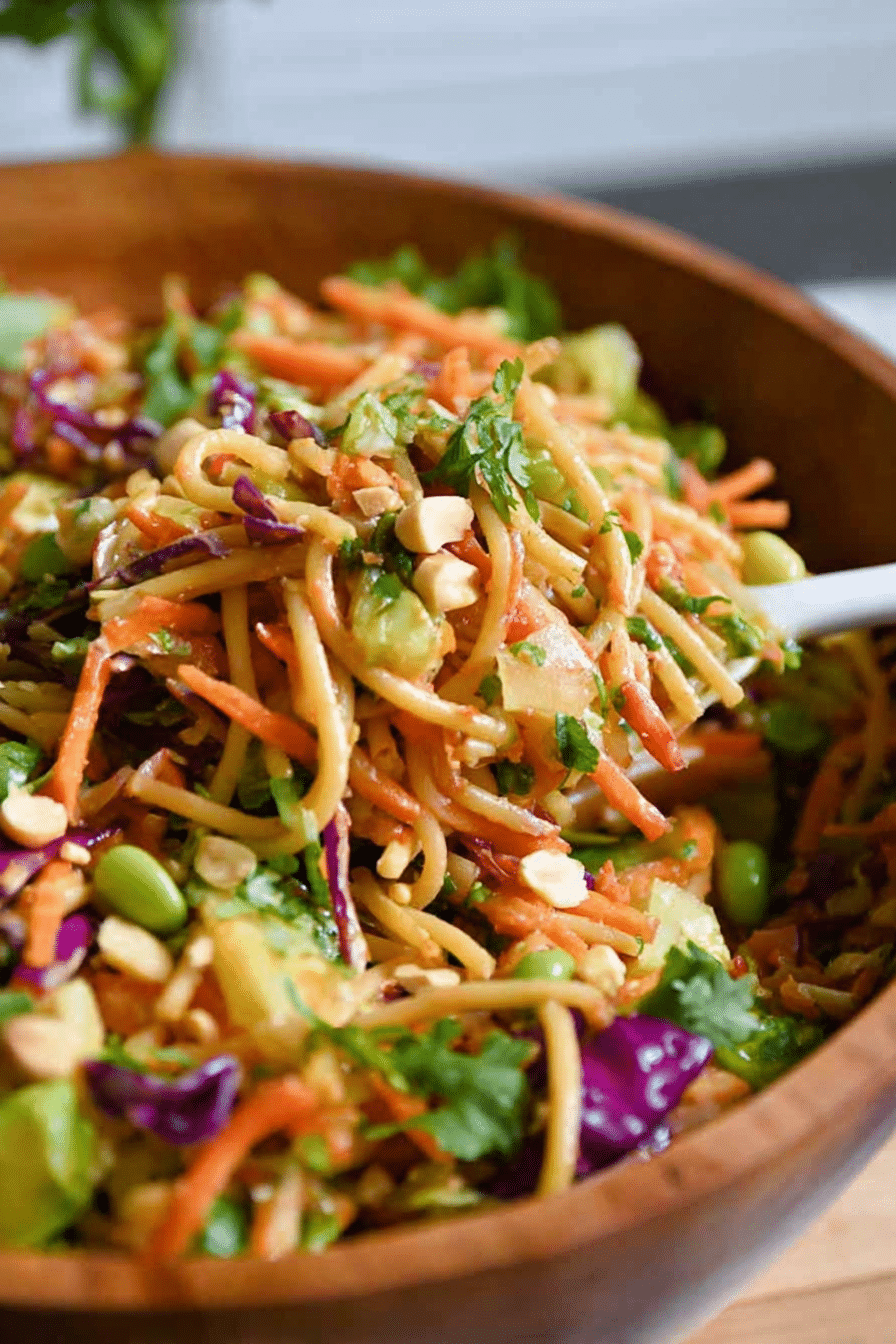 A colorful Thai Spring Roll Pasta Salad with shrimp, vegetables, and herbs in a glass bowl.