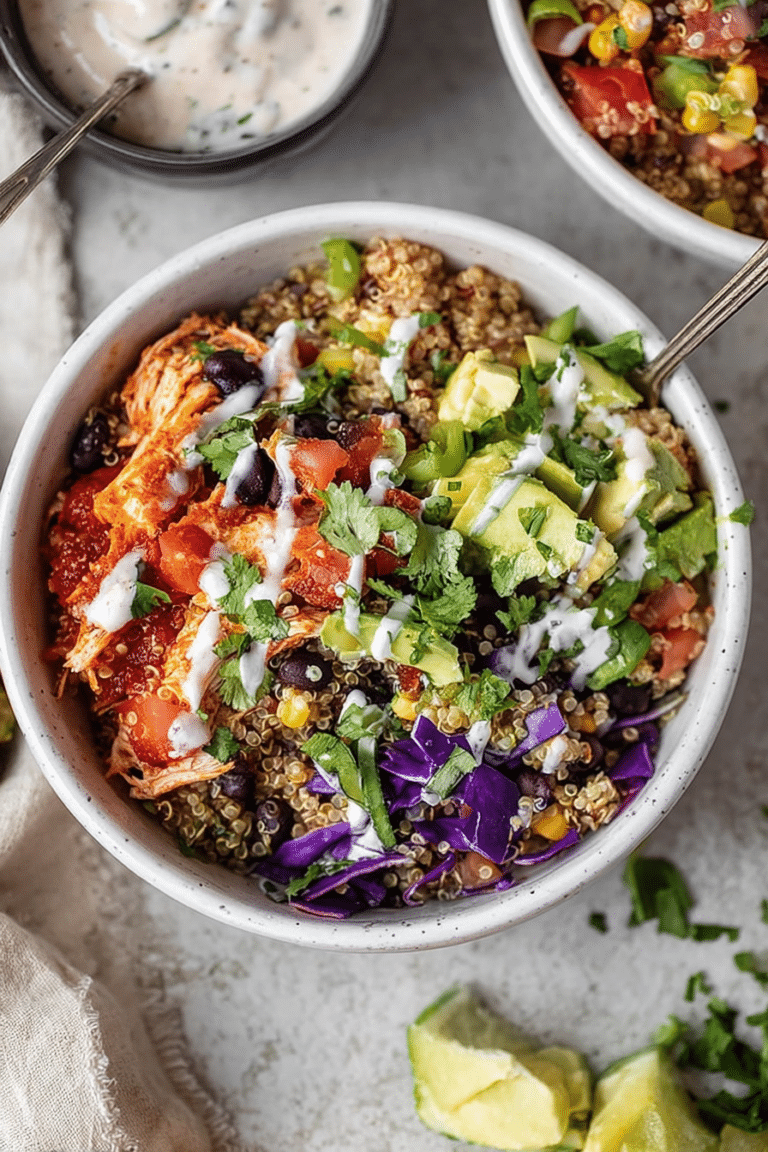 Colorful BBQ ranch chicken quinoa bowl filled with black beans, red cabbage, corn, tomatoes, jalapeño, and avocado