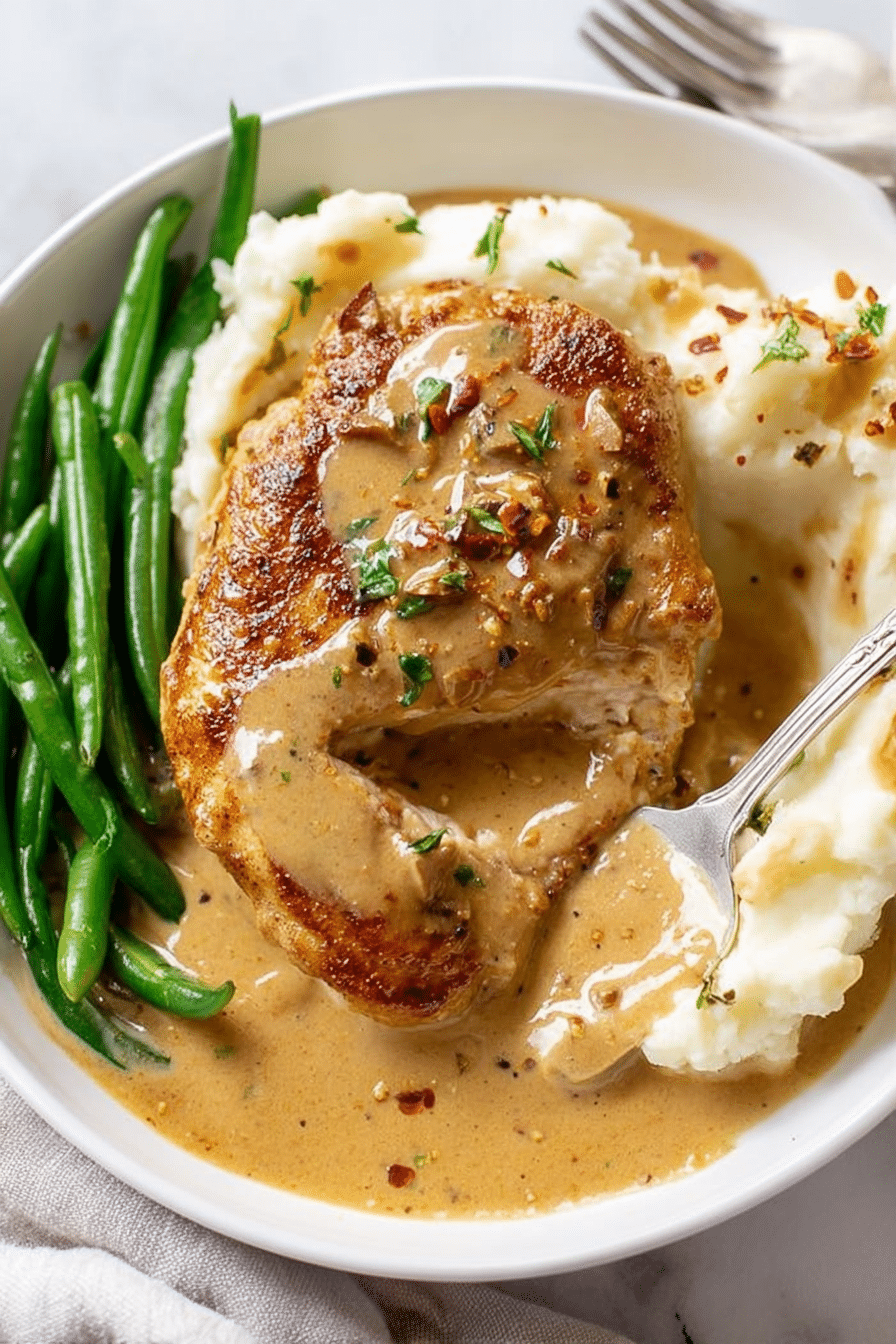 Plated creamy garlic chicken with mashed potatoes and parsley on a wooden table