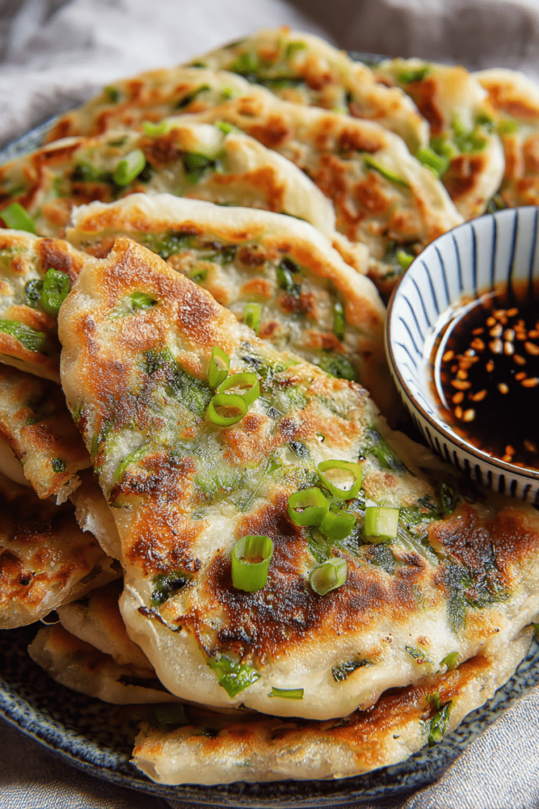 Crispy Chinese scallion pancakes on a plate with dipping sauce and fresh scallions.