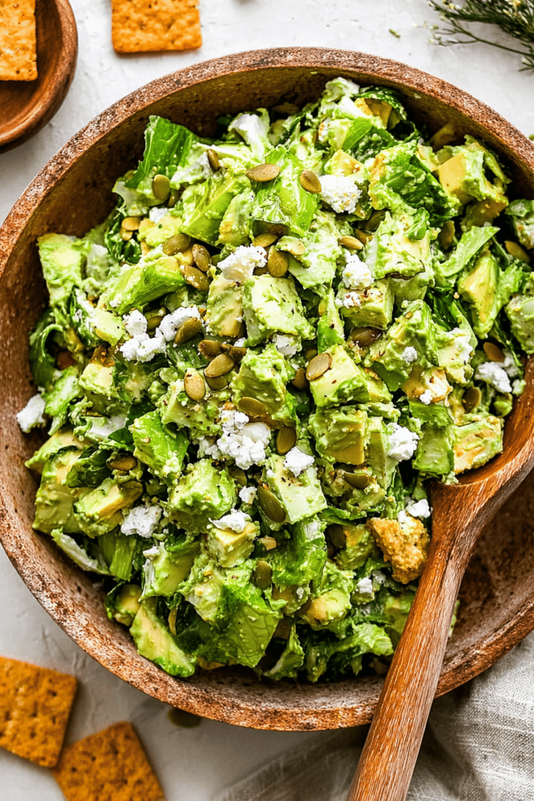 Fresh Green Goddess Salad with avocado, green cabbage, and feta cheese in a glass bowl.