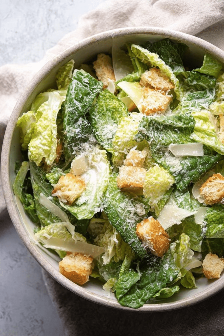 Delicious homemade Caesar salad with croutons and Parmesan on a wooden table.