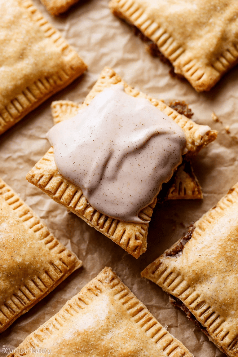 Homemade frosted brown sugar cinnamon pop tart on a rustic wooden table, with a slice cut revealing the filling.