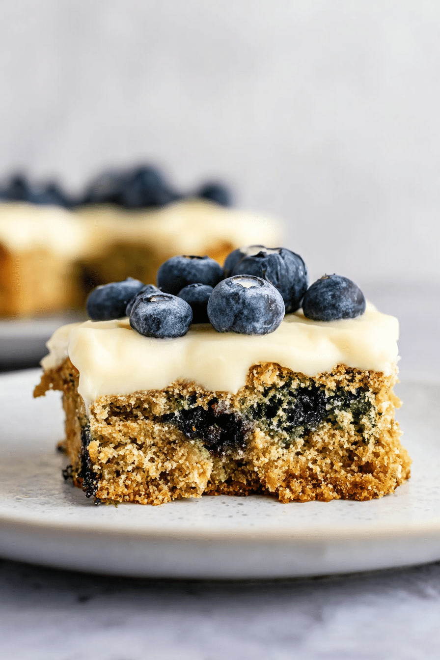 Slice of gluten-free lemon blueberry zucchini cake on a wooden table, garnished with fresh blueberries and lemon slices.