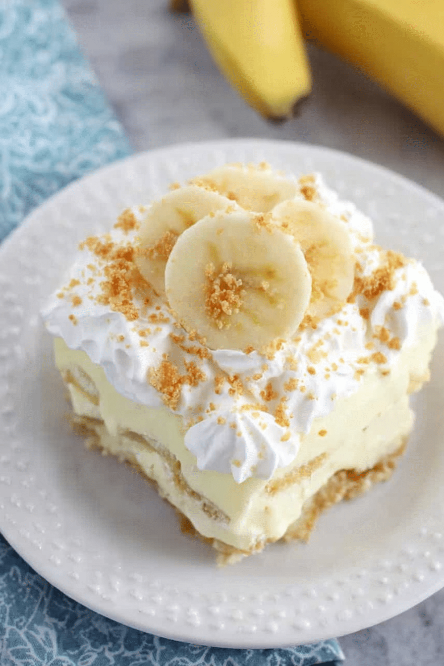 Layered no bake banana pudding dessert with bananas and vanilla pudding topped with crushed wafer cookies.