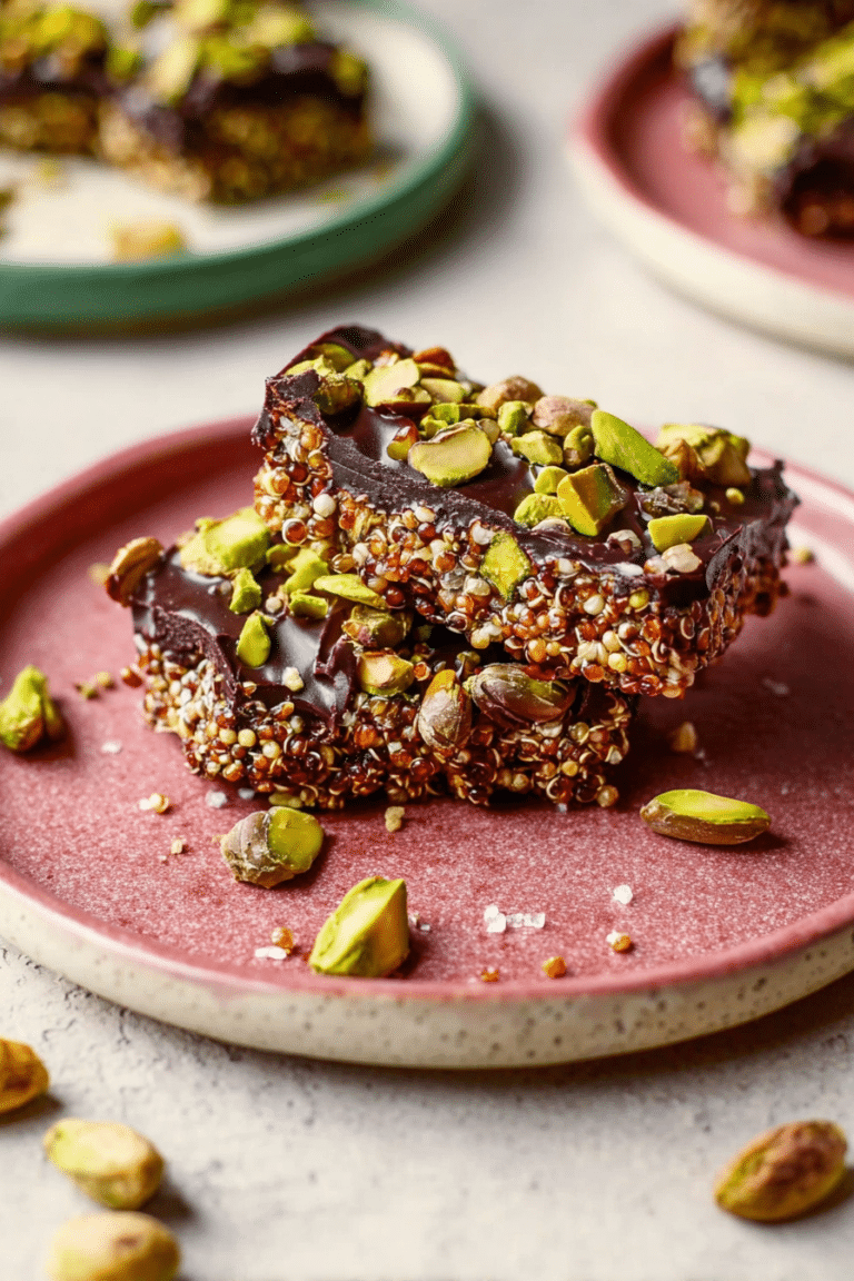 Close-up of salted dark chocolate pistachio quinoa crunch bars with pistachios and melted chocolate, perfect for a healthy snack.
