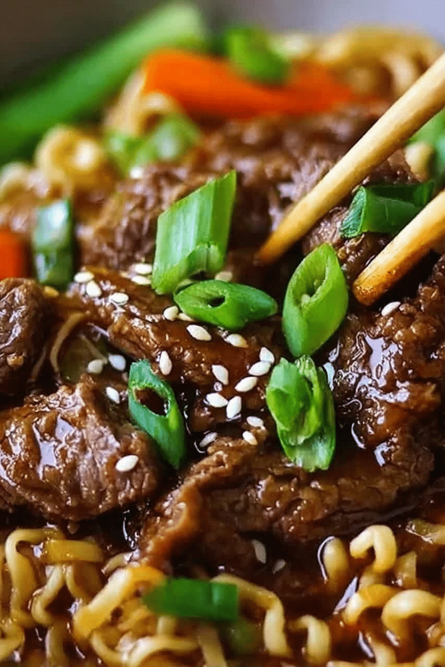 Delicious slow cooker beef ramen noodles served in a bowl with green onions and a soft-boiled egg, garnished with chili oil.
