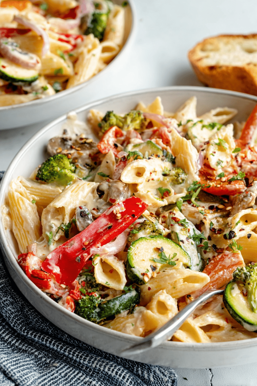Delicious vegan pasta primavera with creamy garlic cashew sauce and fresh vegetables.