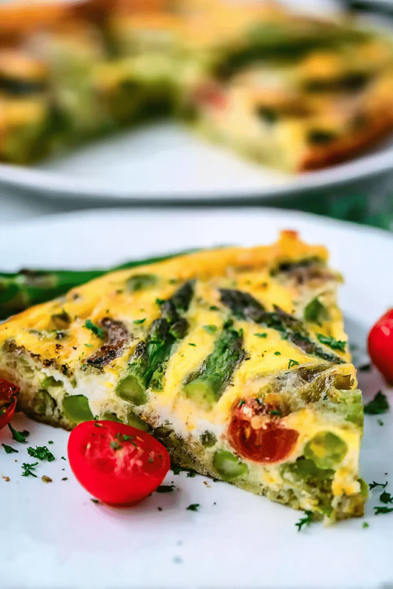Delicious asparagus frittata garnished with fresh cherry tomatoes and asparagus spears, served on a rustic table.
