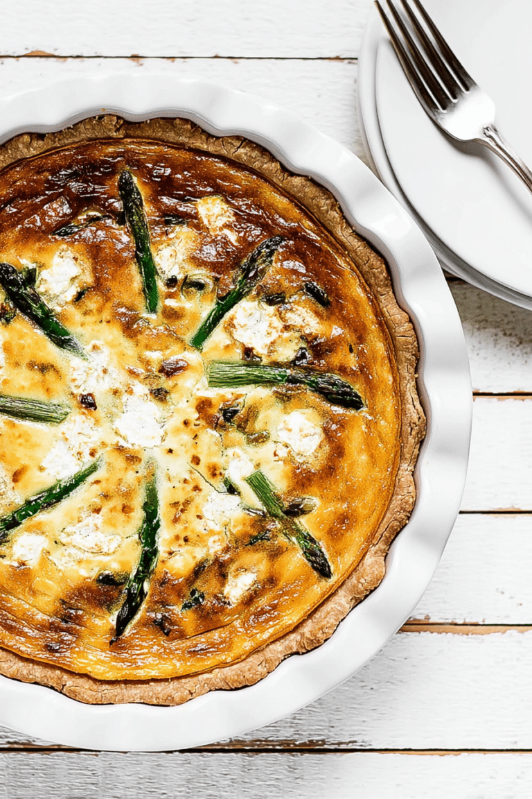 Baked asparagus quiche with goat cheese on a wooden table