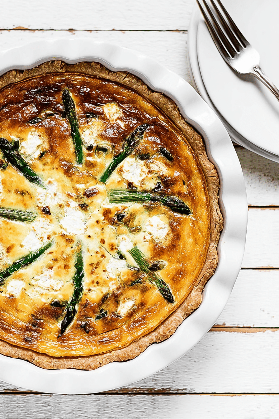 Baked asparagus quiche with goat cheese on a wooden table
