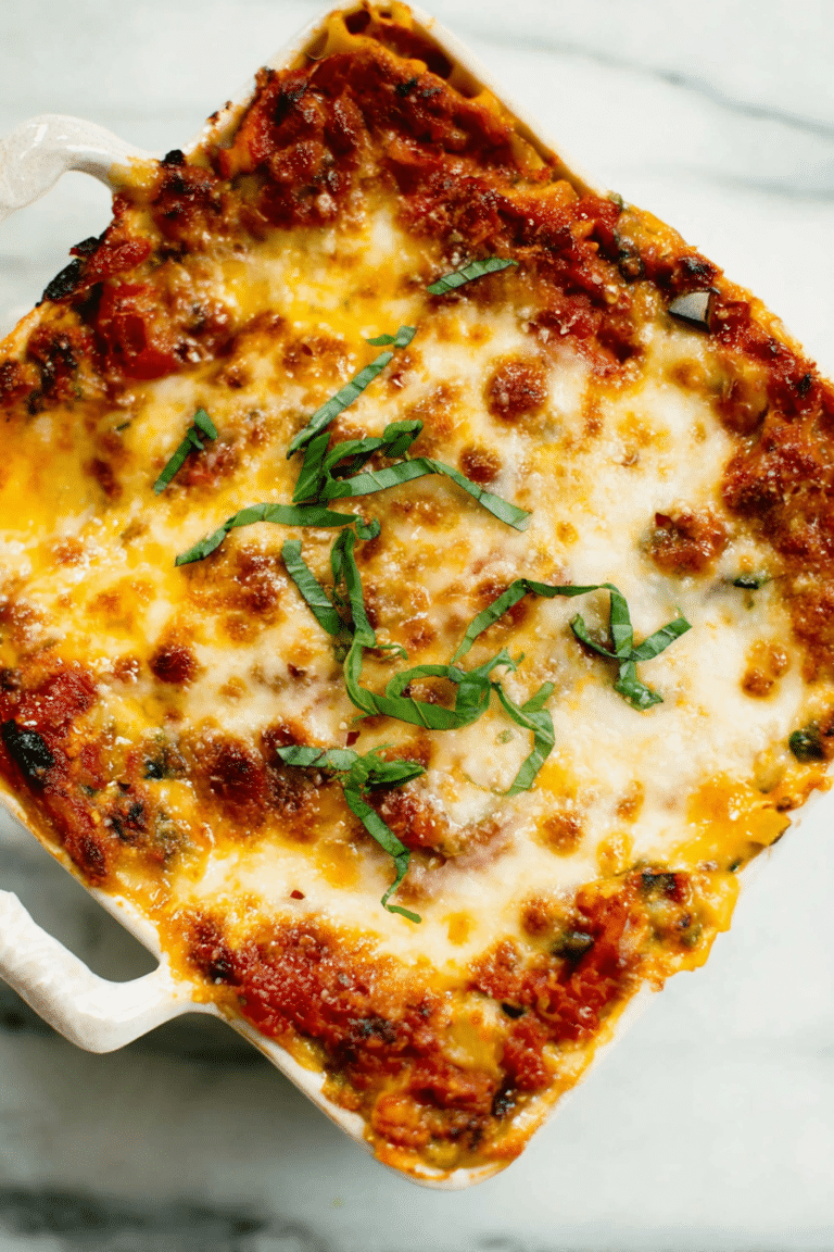 Slice of best vegetable lasagna on a plate with fresh basil garnish