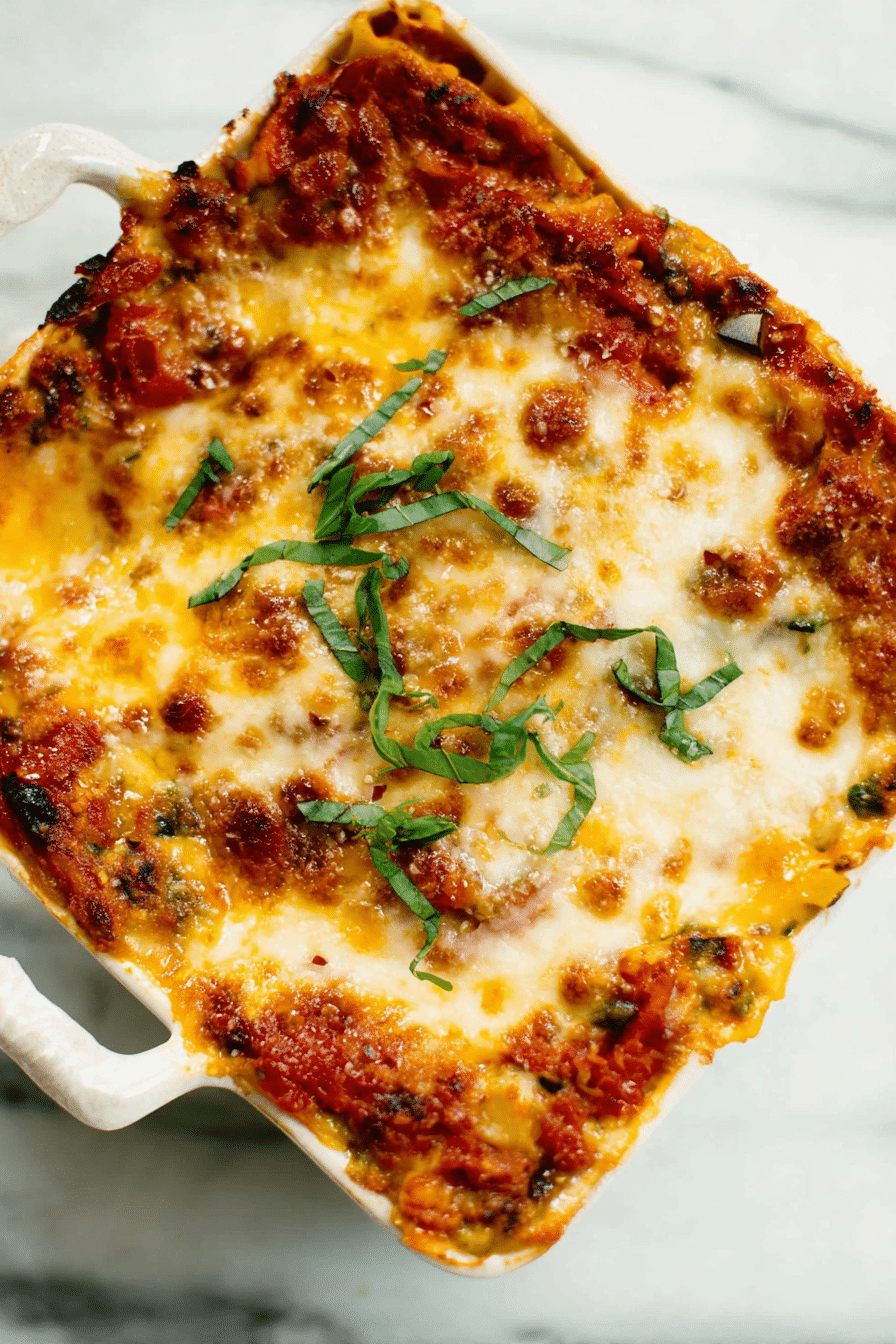 Slice of best vegetable lasagna on a plate with fresh basil garnish