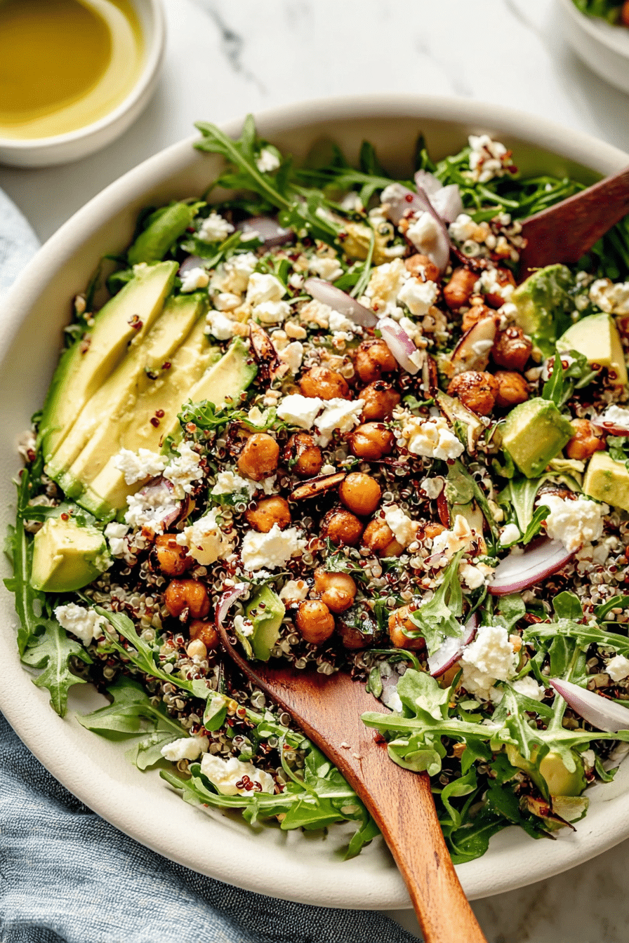 Close-up of chickpea arugula quinoa salad featuring quinoa, arugula, feta, and dates.