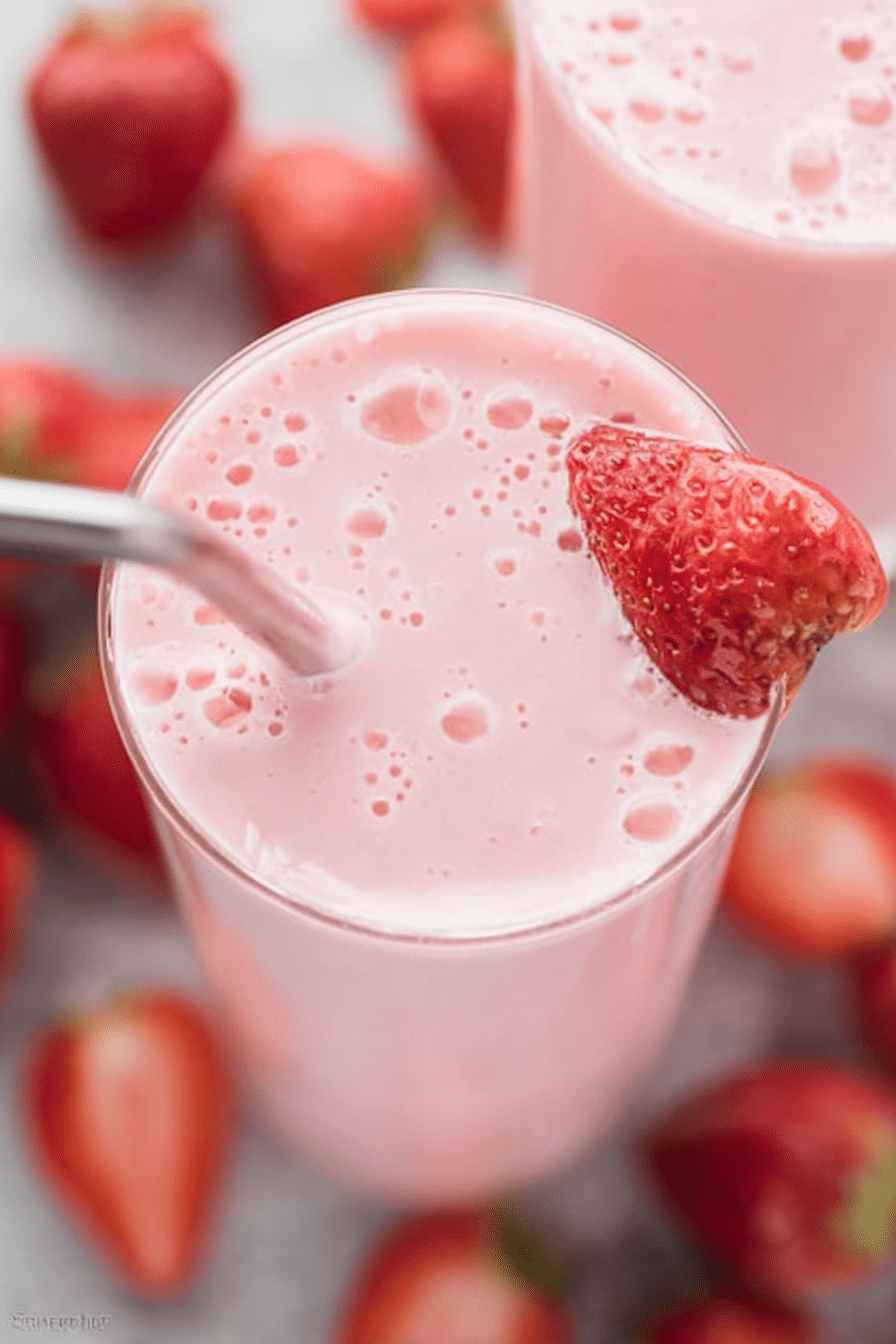 Energizing easy strawberry smoothie served in a glass with fresh strawberries and mint, perfect for a healthy snack.