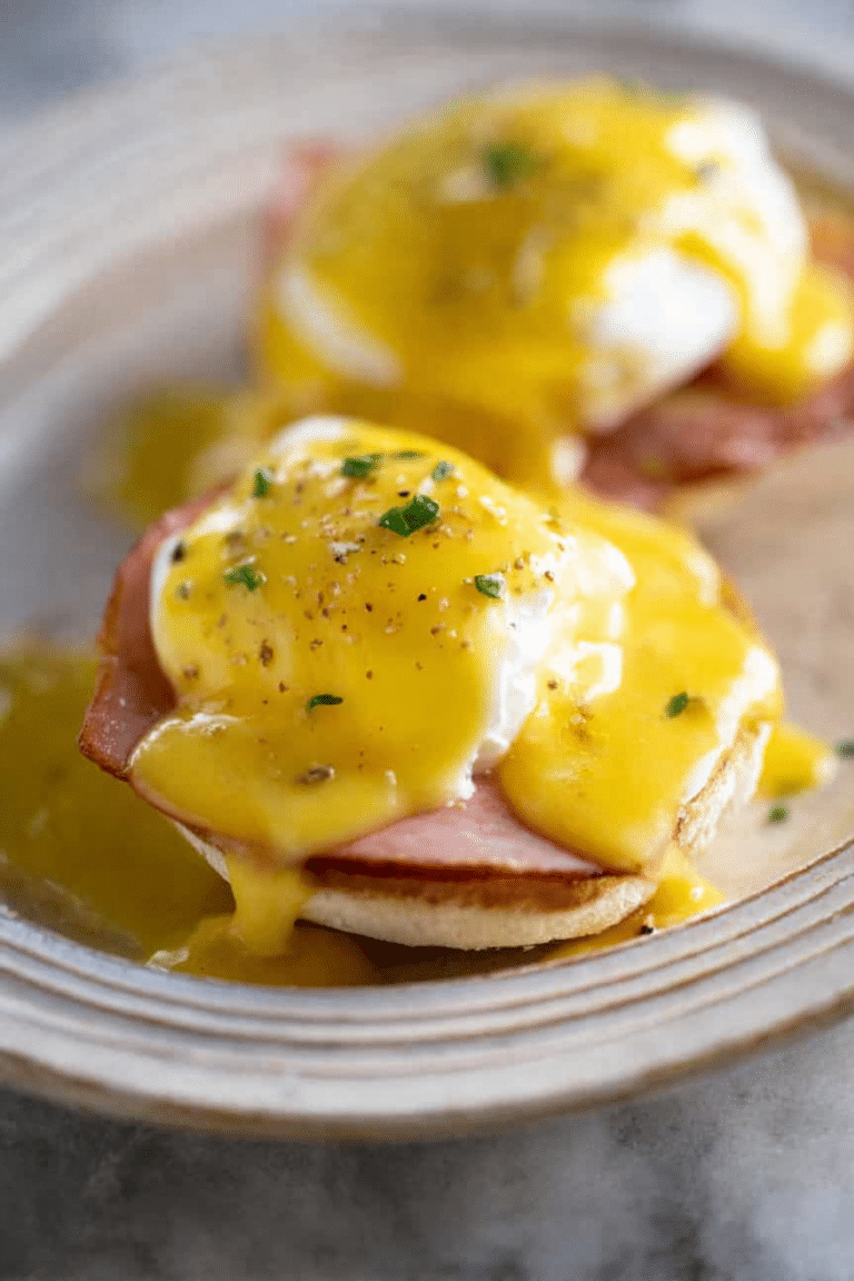 Plated Eggs Benedict with poached eggs, Canadian bacon, and hollandaise sauce on English muffins