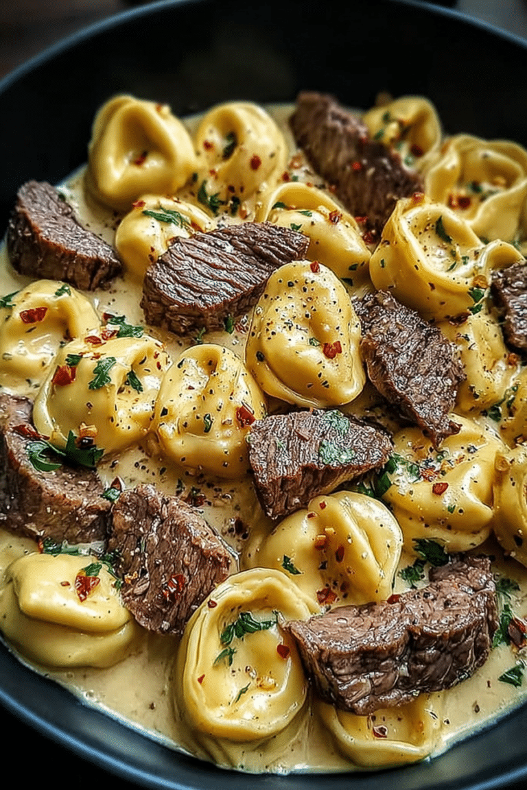 Delicious garlic steak tortellini garnished with parsley and parmesan cheese in a rustic bowl.