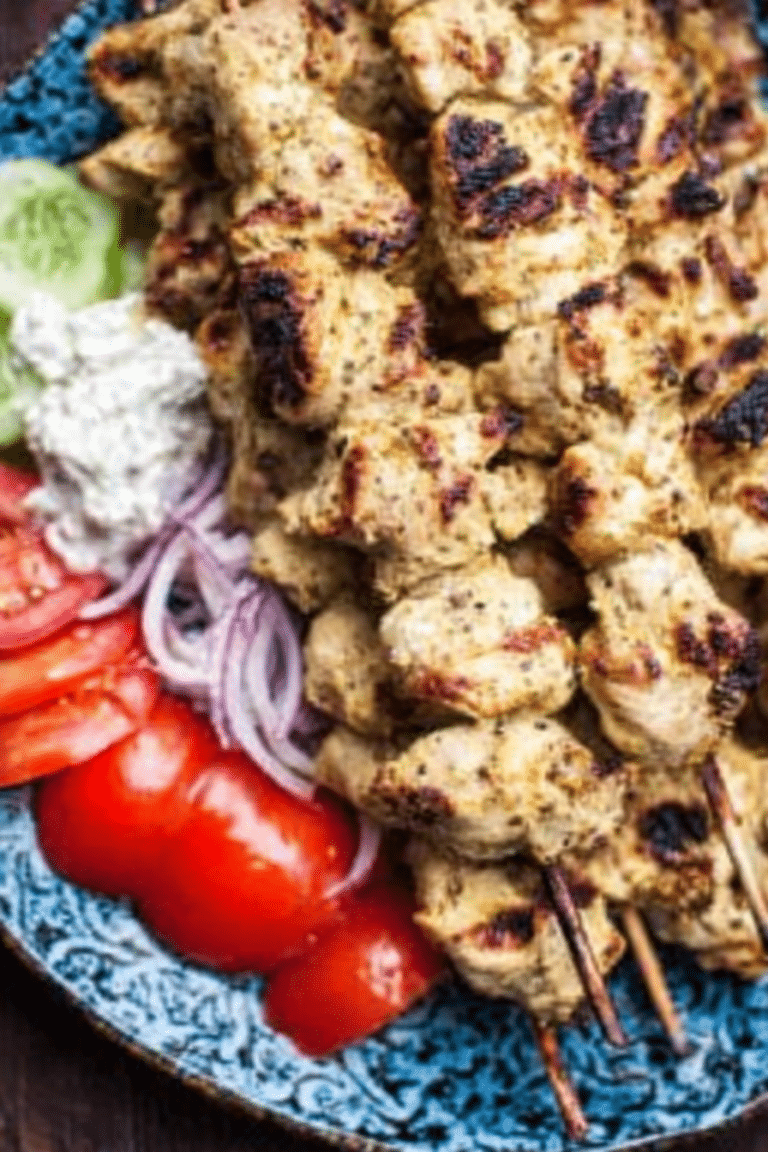 Delicious Greek chicken souvlaki skewers served with Tzatziki sauce and fresh vegetables.