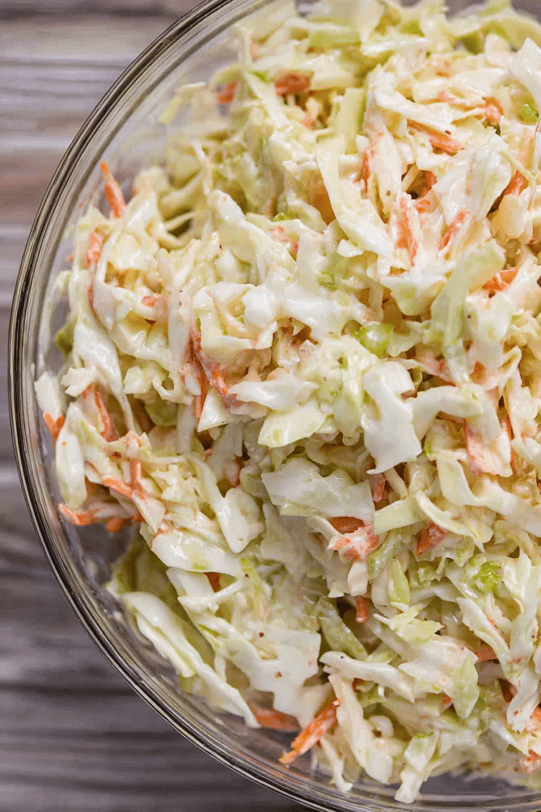 Homemade coleslaw in a colorful bowl with fresh herbs, perfect side dish for barbecues.