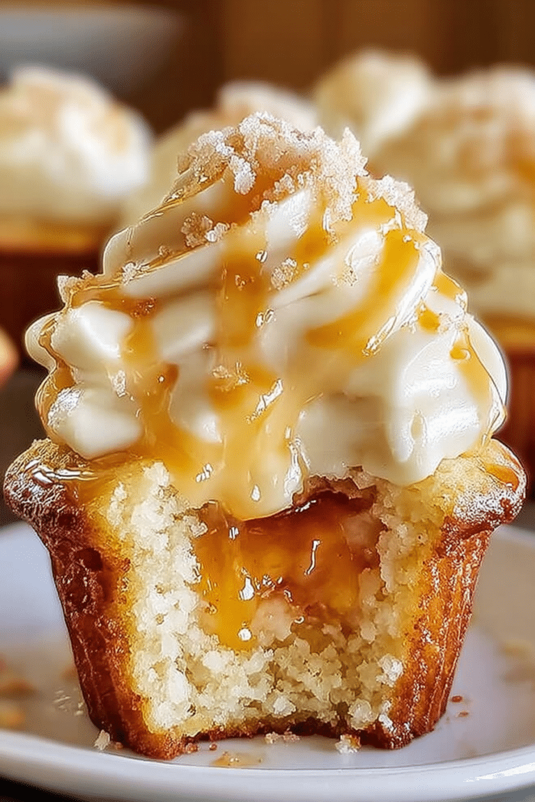 Close-up of honey peach cream cheese cupcakes with cream cheese frosting, garnished with peach slices and honey drizzle.