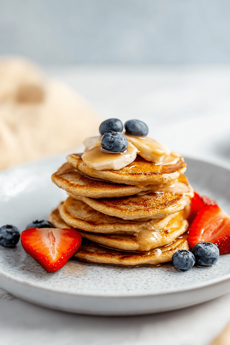Kid-friendly banana pancakes stacked high, garnished with fresh berries and honey, perfect for a nutritious breakfast.