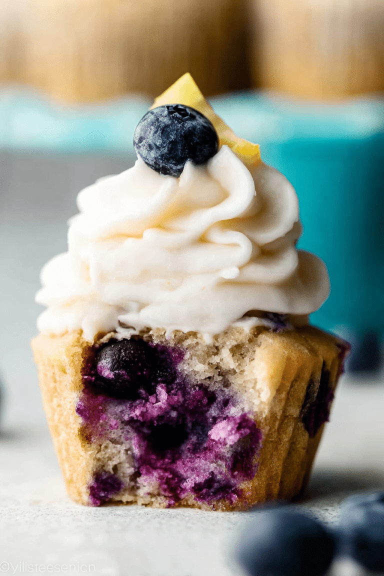 Delicious lemon blueberry cupcakes topped with cream cheese frosting and fresh blueberries.