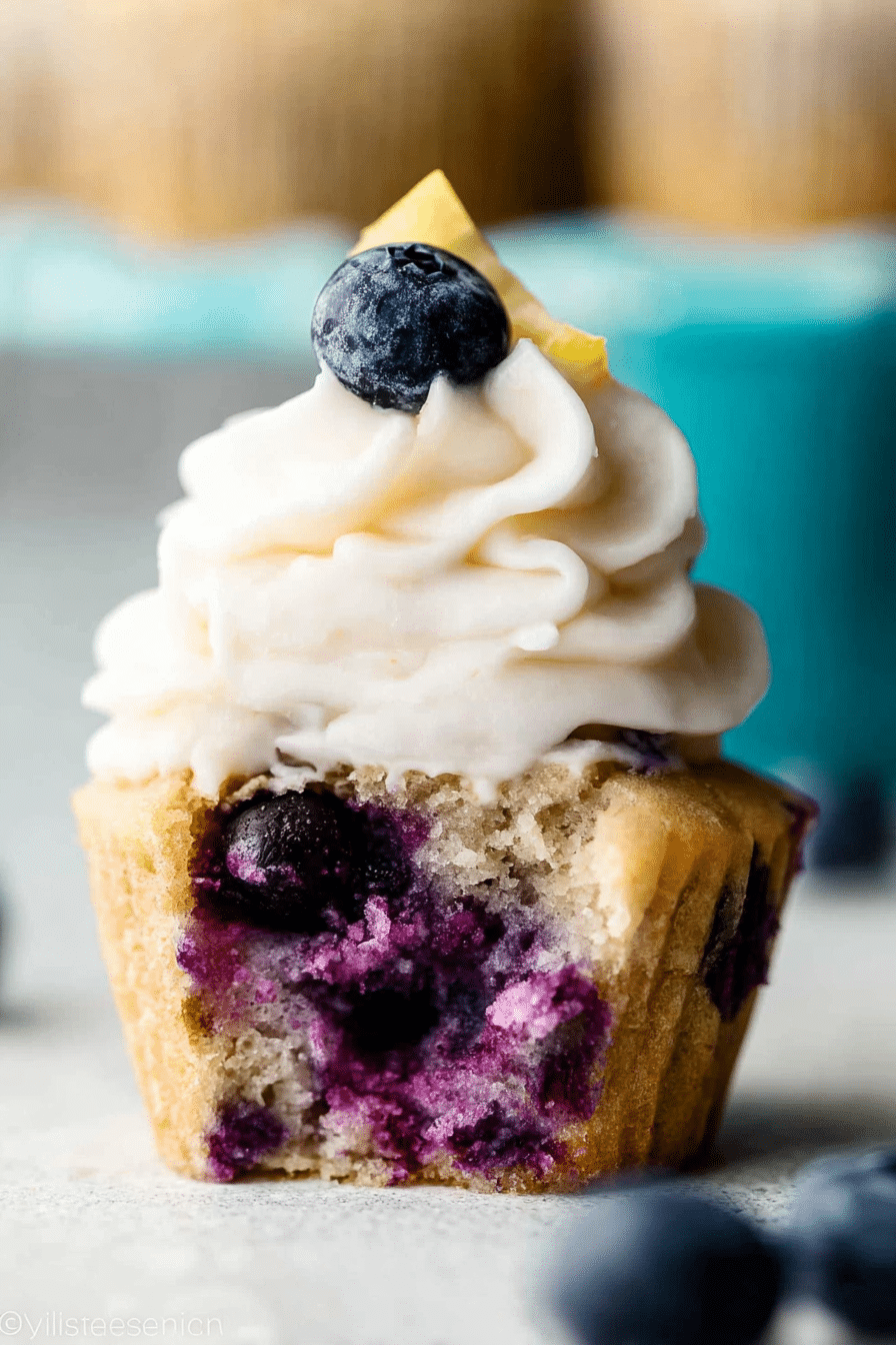 Delicious lemon blueberry cupcakes topped with cream cheese frosting and fresh blueberries.