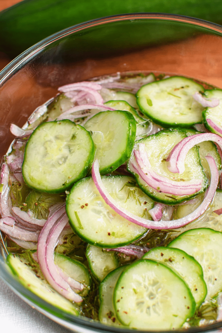 Old fashioned cucumber salad with cucumbers and red onions in vinegar dressing garnished with dill.