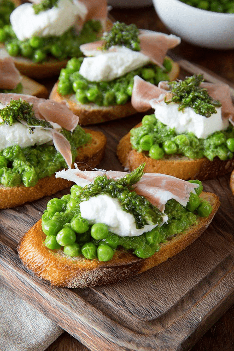 Plate of Spring Pea Crostini with burrata and prosciutto on a wooden table
