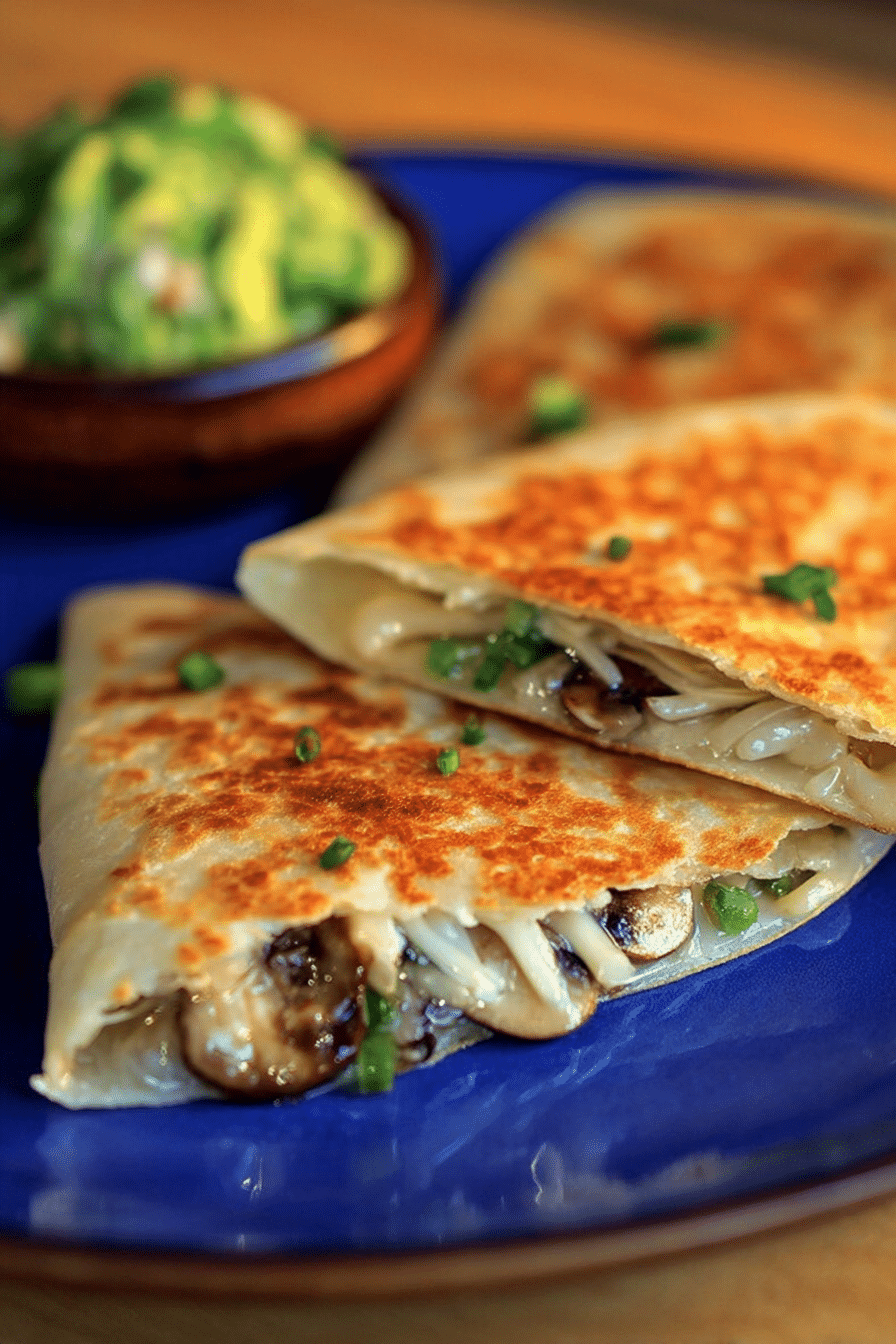 Delicious wild mushroom quesadilla filled with gooey cheese and fresh herbs on a wooden table.