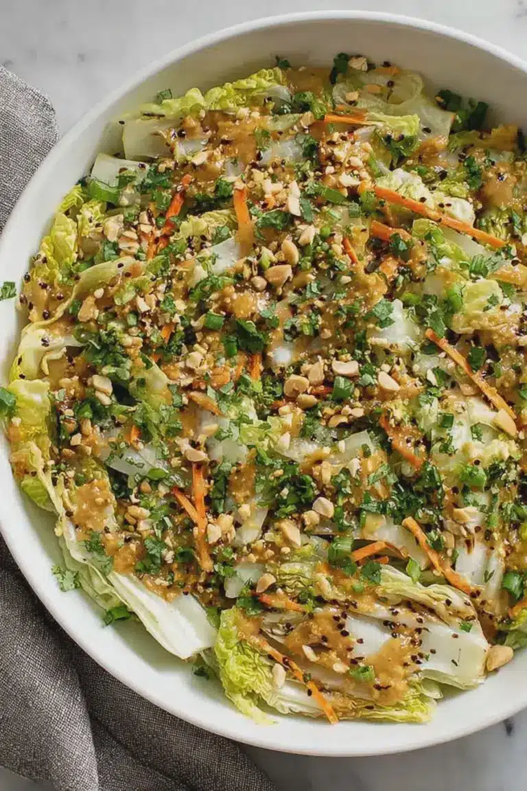 Fresh napa cabbage salad with peanuts and sesame seeds on a wooden table.