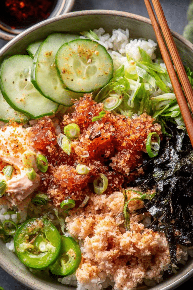 Spicy Tuna Sushi Bowl with crispy rice, cucumbers, and scallions on a wooden table